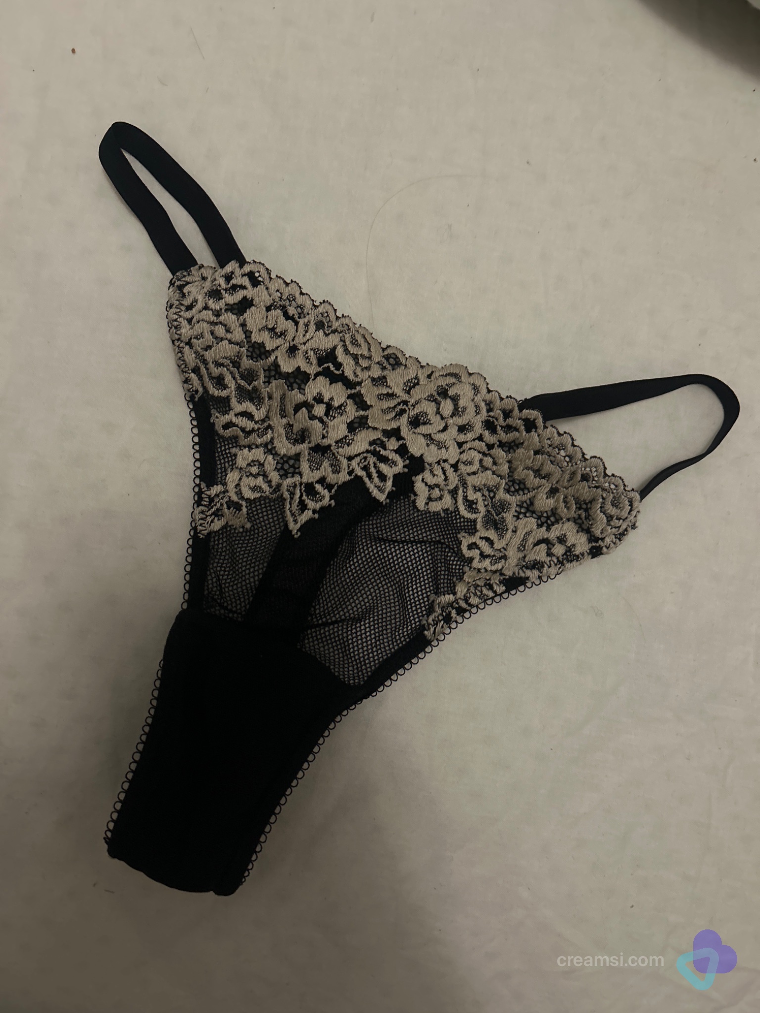 Schwarzer Tanga mit Bestickung weiß